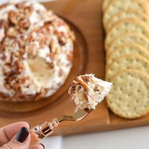 BEST Cheeseball Ever on a serving spoon in hand